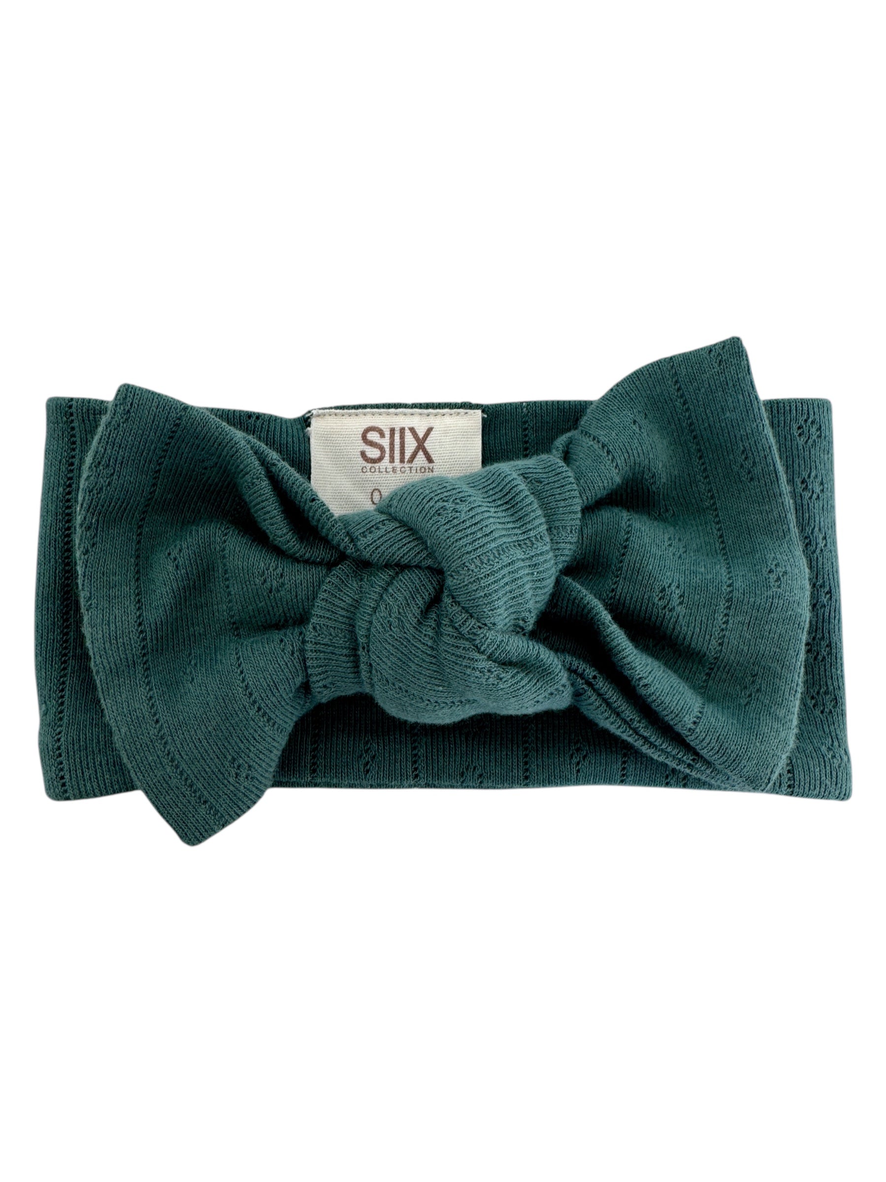Teal knit headband with a bow and a tag reading "SIIX COLLECTION."