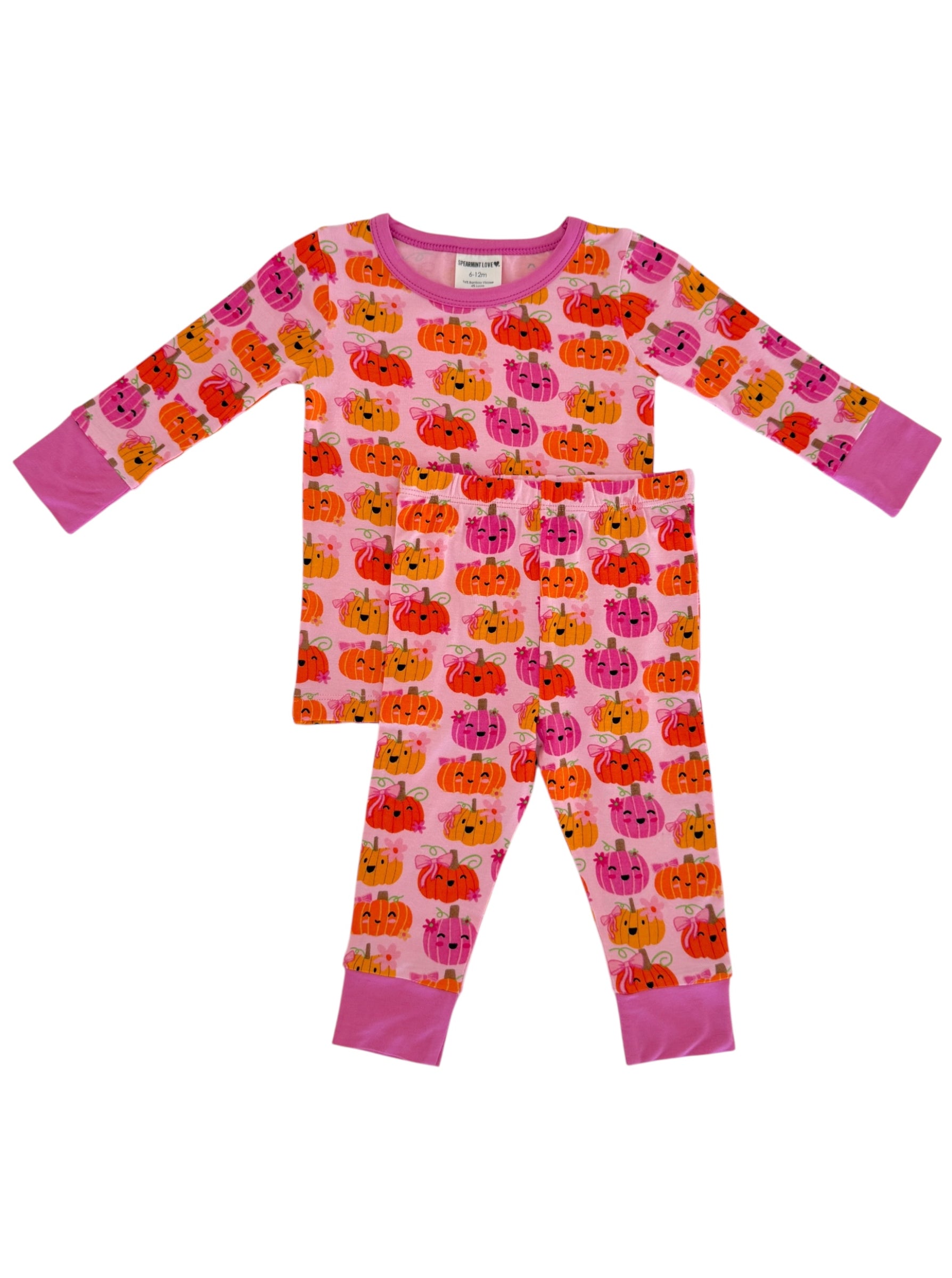 Pink pajamas with playful pumpkin patterns, featuring a long-sleeve top and matching pants.