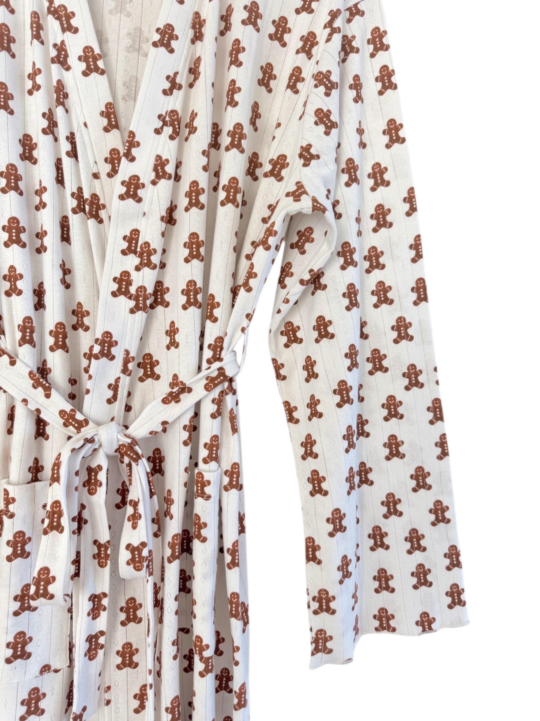 White robe with gingerbread man print, featuring a belt and long sleeves. Ideal for cozy, festive wear.