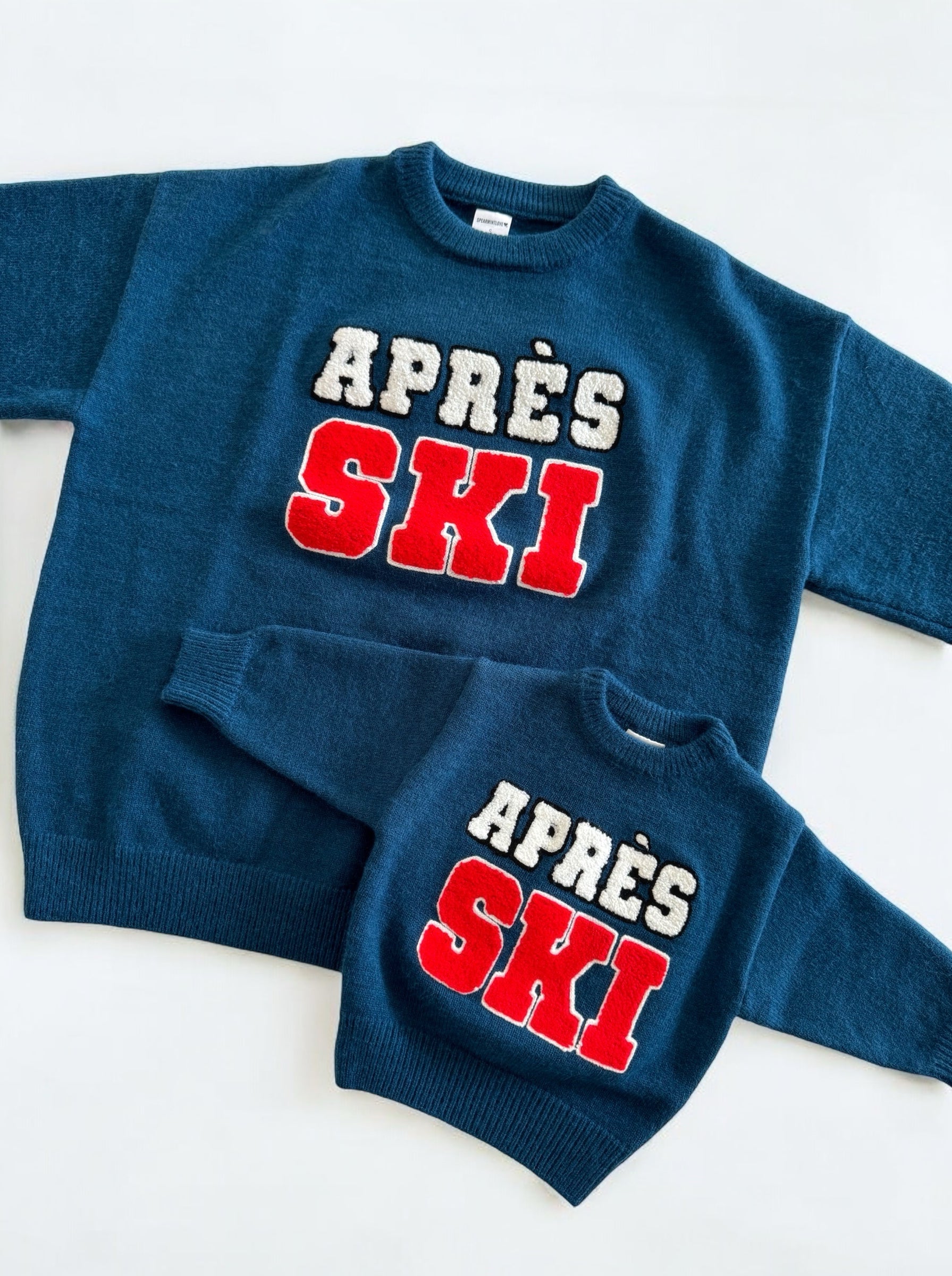 Matching blue sweaters for adults and children featuring "APRÈS SKI" in bold red and white letters.