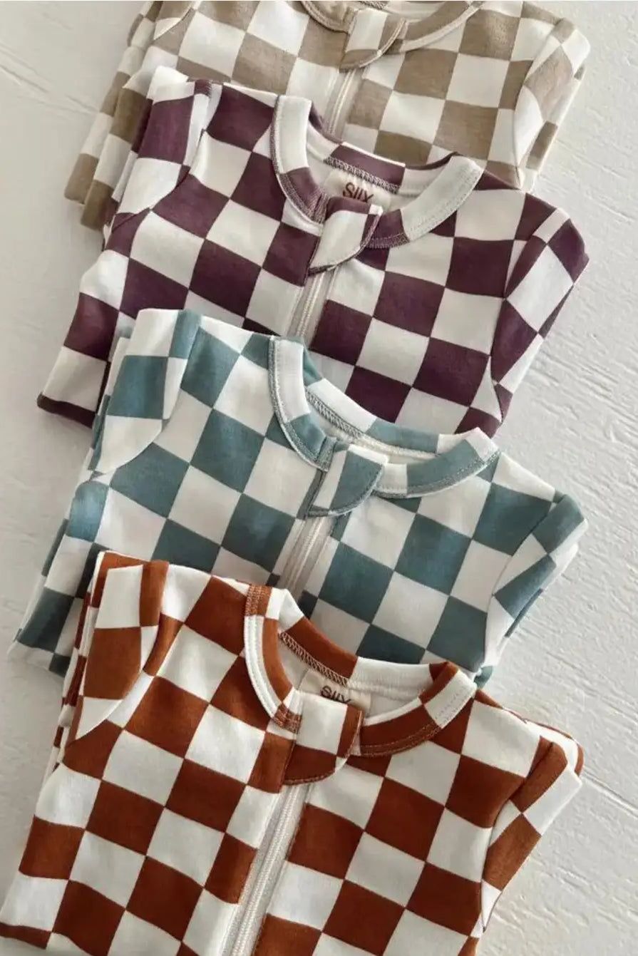 Colorful checkered zip-up pajamas stacked neatly in four different colors on a white background.