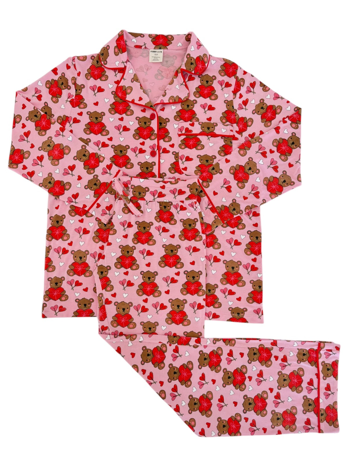 Pink pajama set featuring bears and hearts, perfect for cozy nights. Includes a button-up top and matching pants.