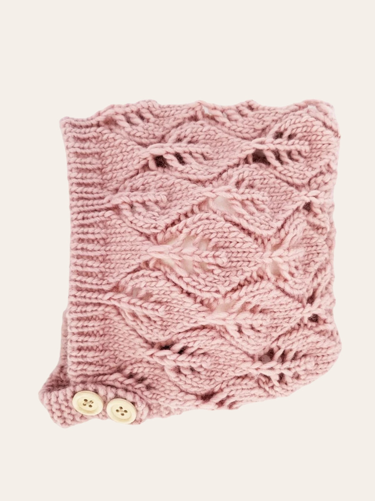 Pink knitted cowl scarf with a lace pattern and two button closures.