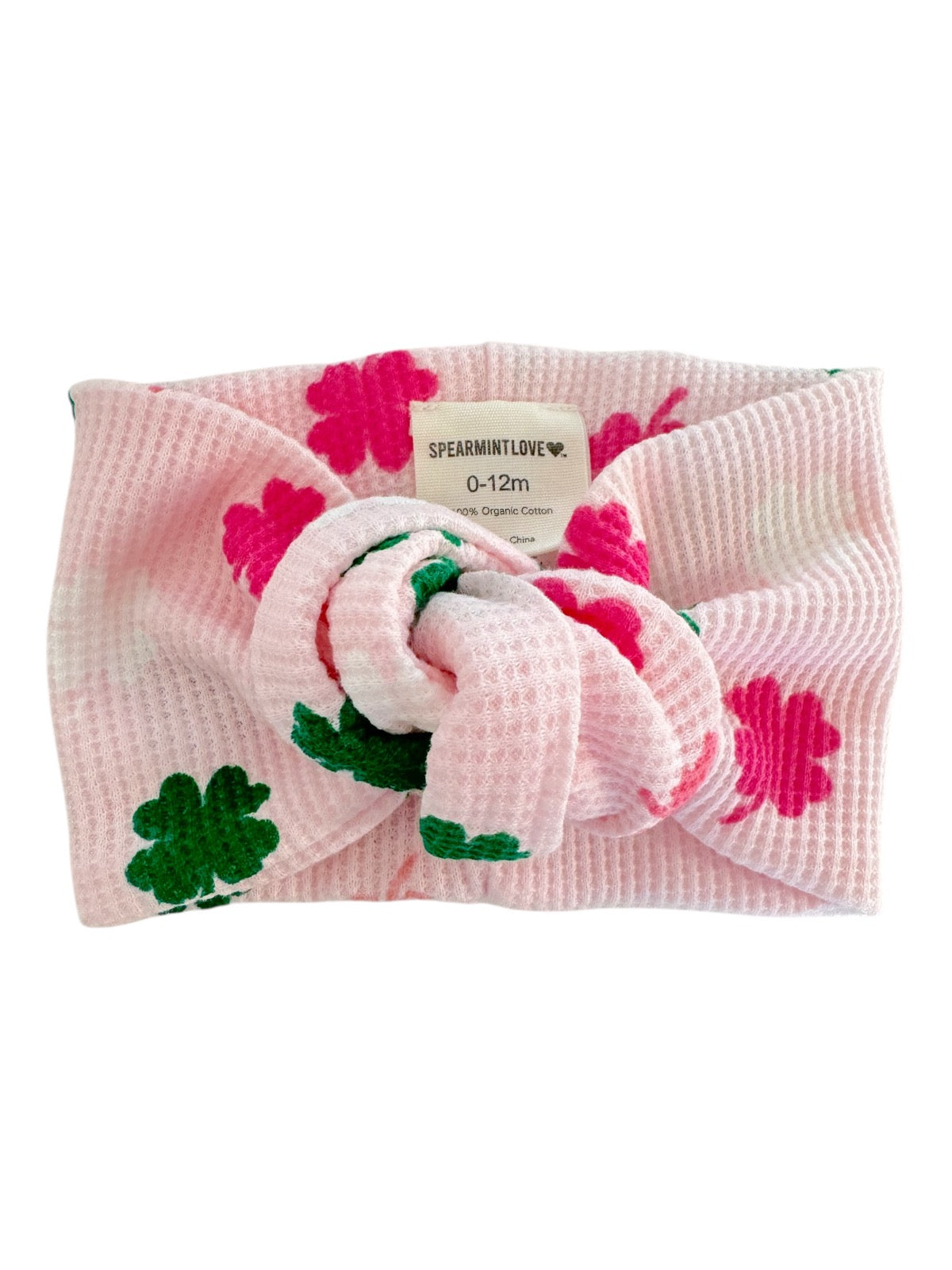 Pink toddler headband with floral pattern and bow, made from 100% organic cotton, suitable for ages 0-12 months.