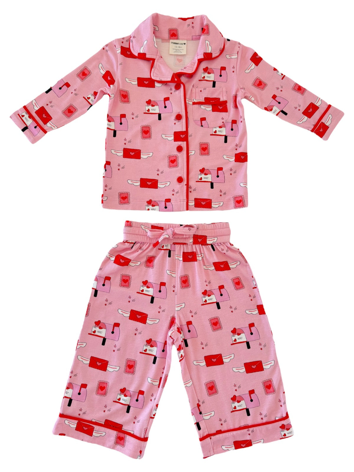 Pink pajama set for kids featuring envelopes and hearts, with a button-up shirt and matching pants.