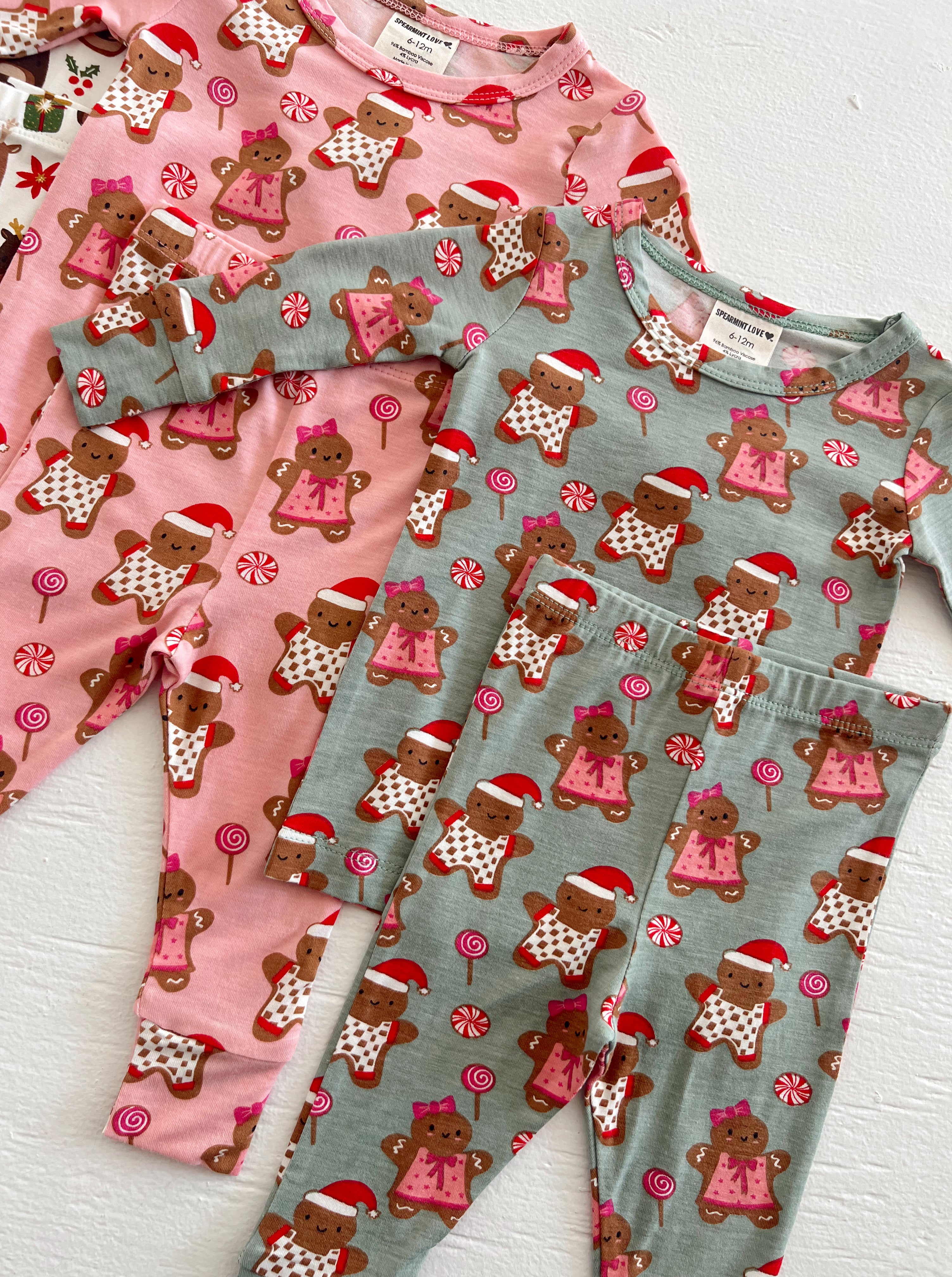 Gingerbread-themed children's pajamas in pink and gray with festive patterns and candy decorations.