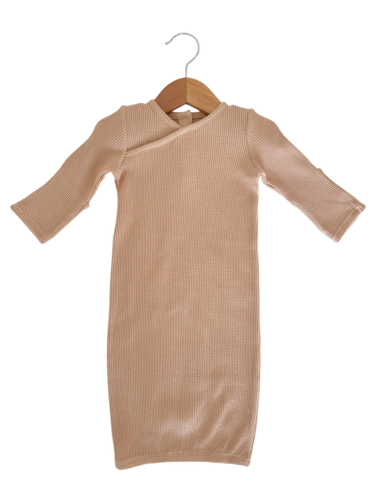Beige ribbed dress with long sleeves hanging on a wooden hanger against a white background.