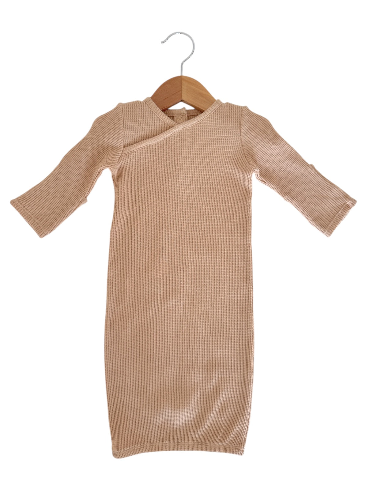 Beige ribbed dress with long sleeves hanging on a wooden hanger against a white background.
