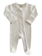 Cream-colored baby onesie with ribbed texture and front zipper. Designed for ages 0-3 months.