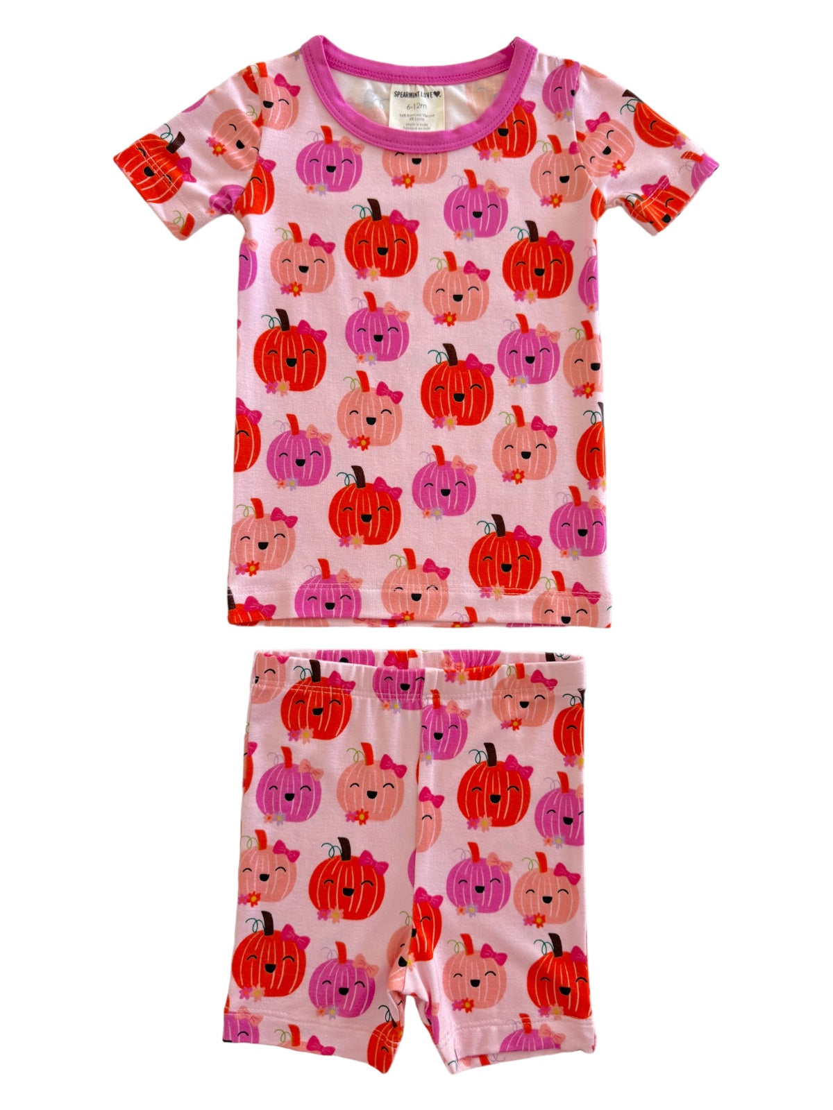 Child's pink pajamas with colorful pumpkin patterns, featuring a short-sleeve top and shorts. Perfect for fall!