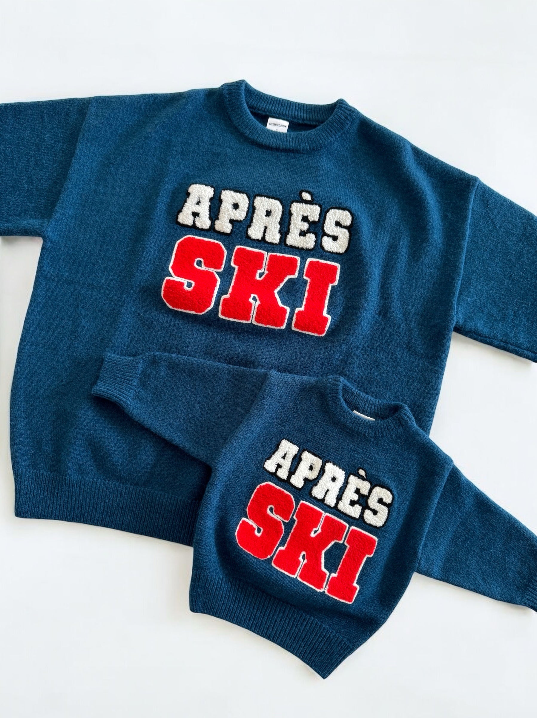 Matching blue sweaters for adults and kids with "APRÈS SKI" text in red and white. Perfect for winter outings.