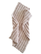 Cozy, textured beige blanket folded stylishly with ribbed pattern, perfect for warmth and comfort.