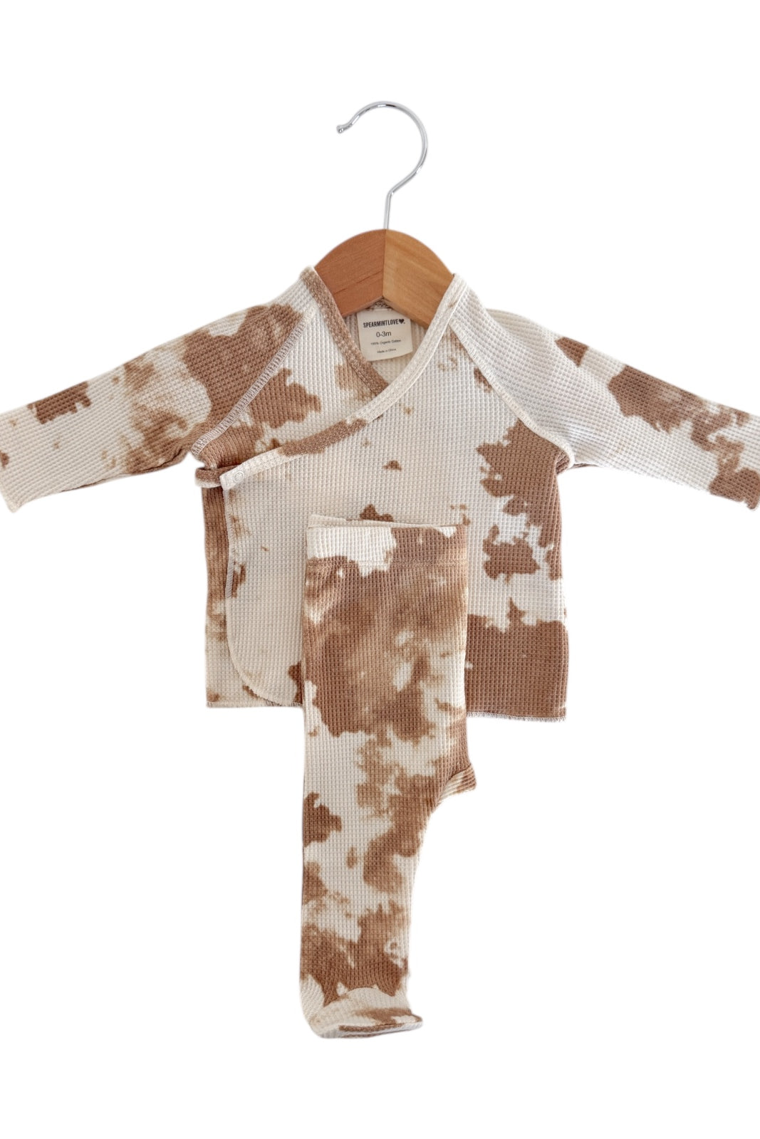 Brown and white tie-dye infant outfit on a hanger, featuring a wrap top and matching leggings.
