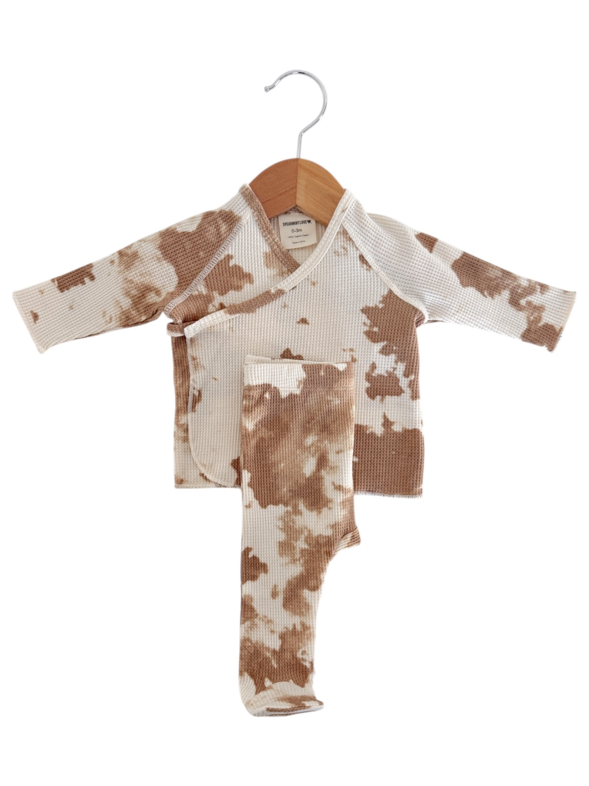 Brown and white tie-dye infant outfit on a hanger, featuring a wrap top and matching leggings.