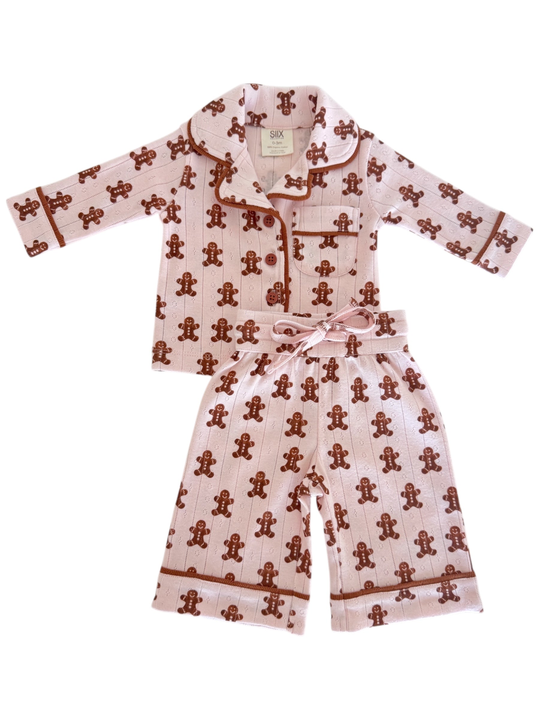 Pink pajama set with gingerbread man pattern, featuring long-sleeve top and shorts, ideal for cozy nights.