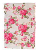 Floral fabric with pink roses and green leaves on a white background, folded neatly.