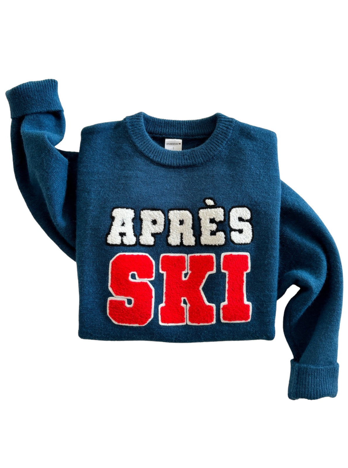 Blue sweater with "APRES SKI" in bold red and white letters. Cozy winter apparel for après-ski activities.