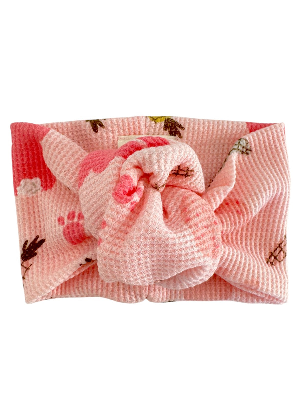 Pink textured headband with a bow, featuring colorful floral and paw prints patterns.