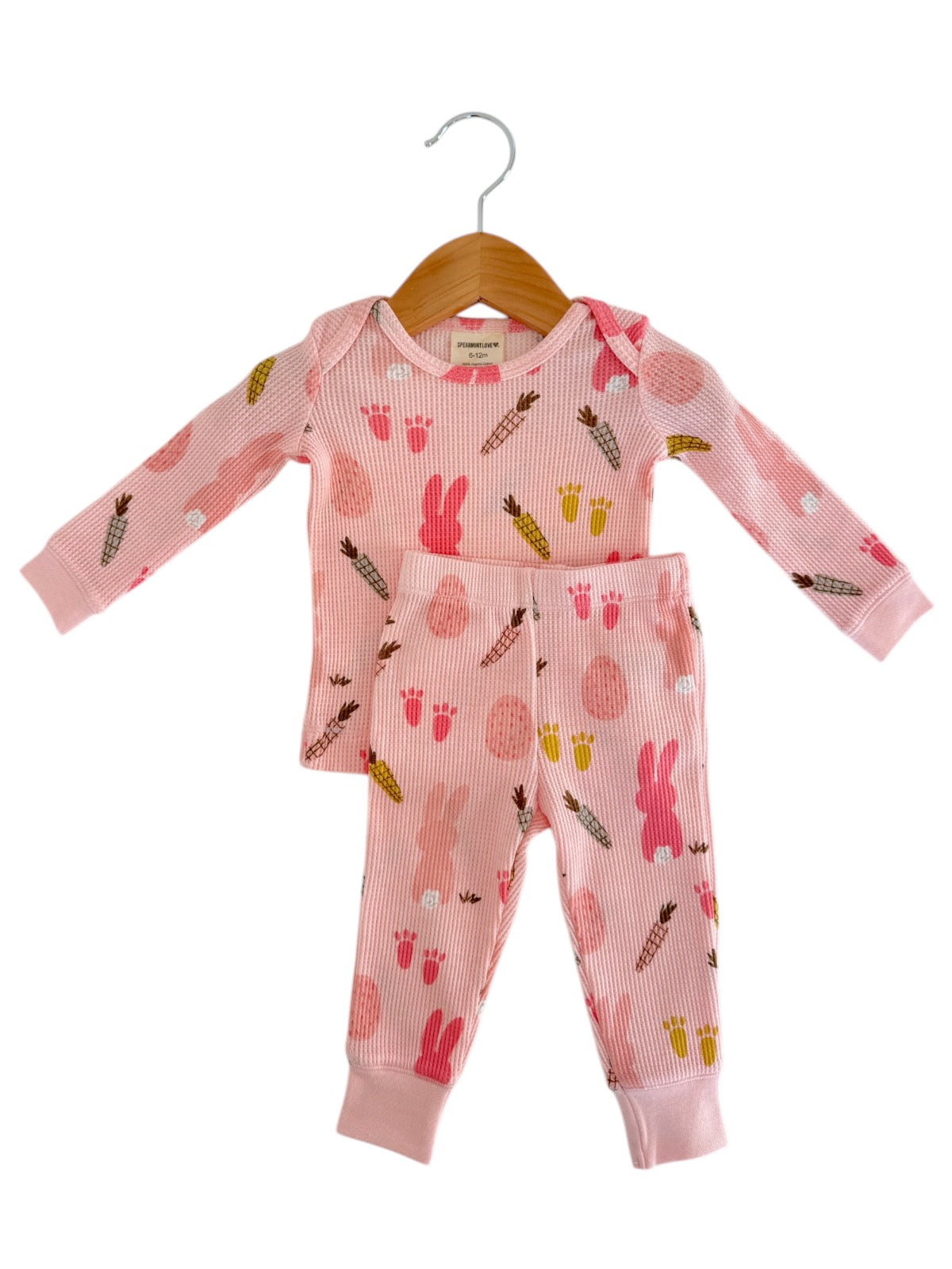 Pink kids' pajama set with bunny and egg patterns, featuring long sleeves and matching pants.