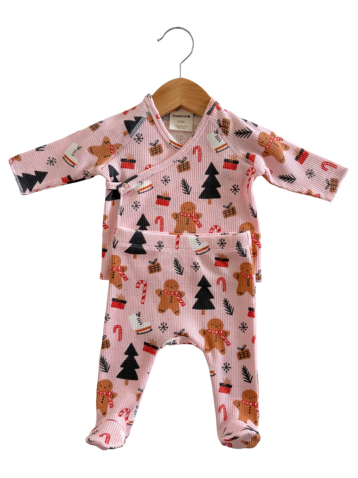 Pink baby outfit with gingerbread and holiday patterns, featuring a wrap top and matching pants.