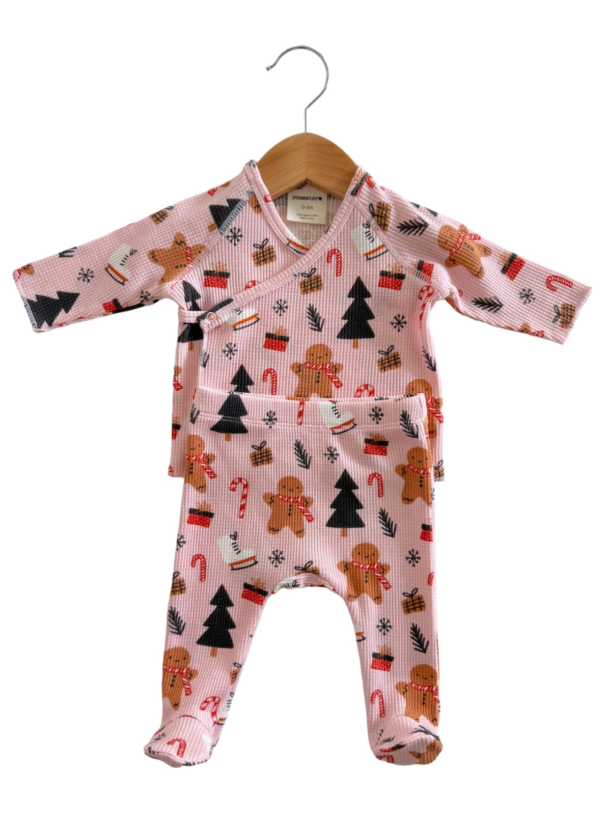 Pink baby outfit with gingerbread and holiday patterns, featuring a wrap top and matching pants.