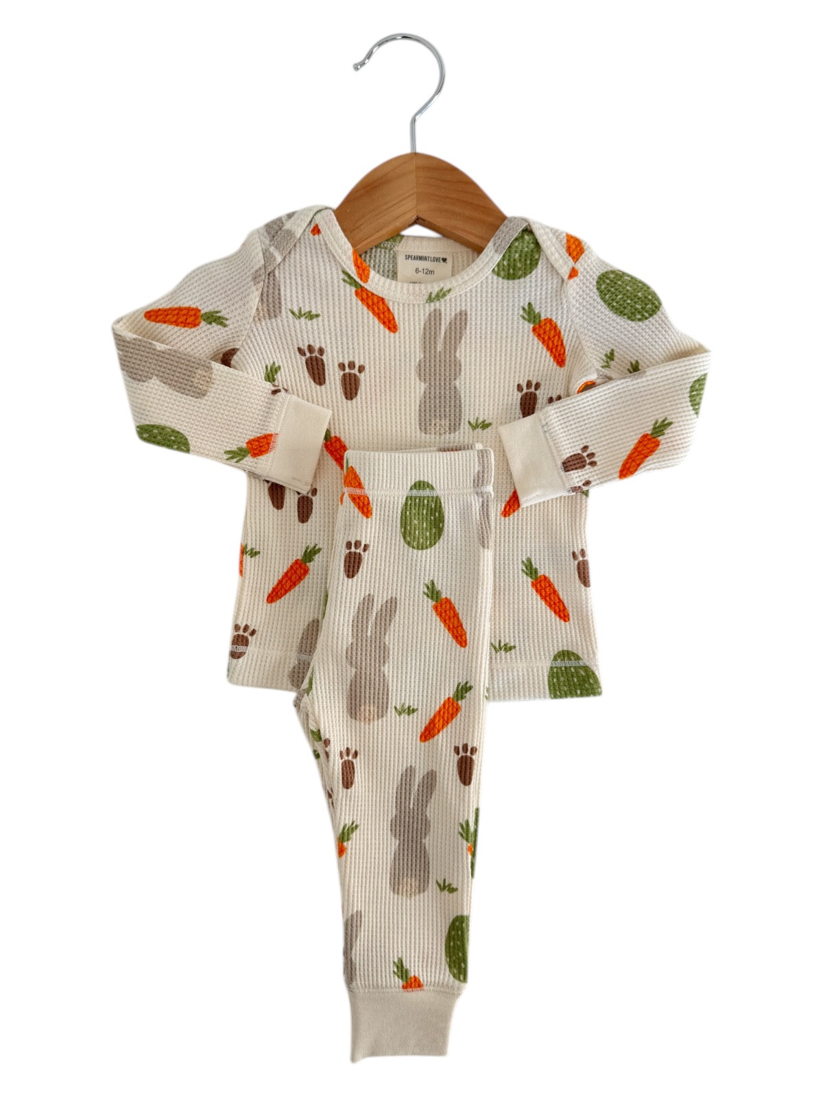 Children's pajama set with bunny and carrot pattern, hanging on a wooden hanger. Size 6-12 months.