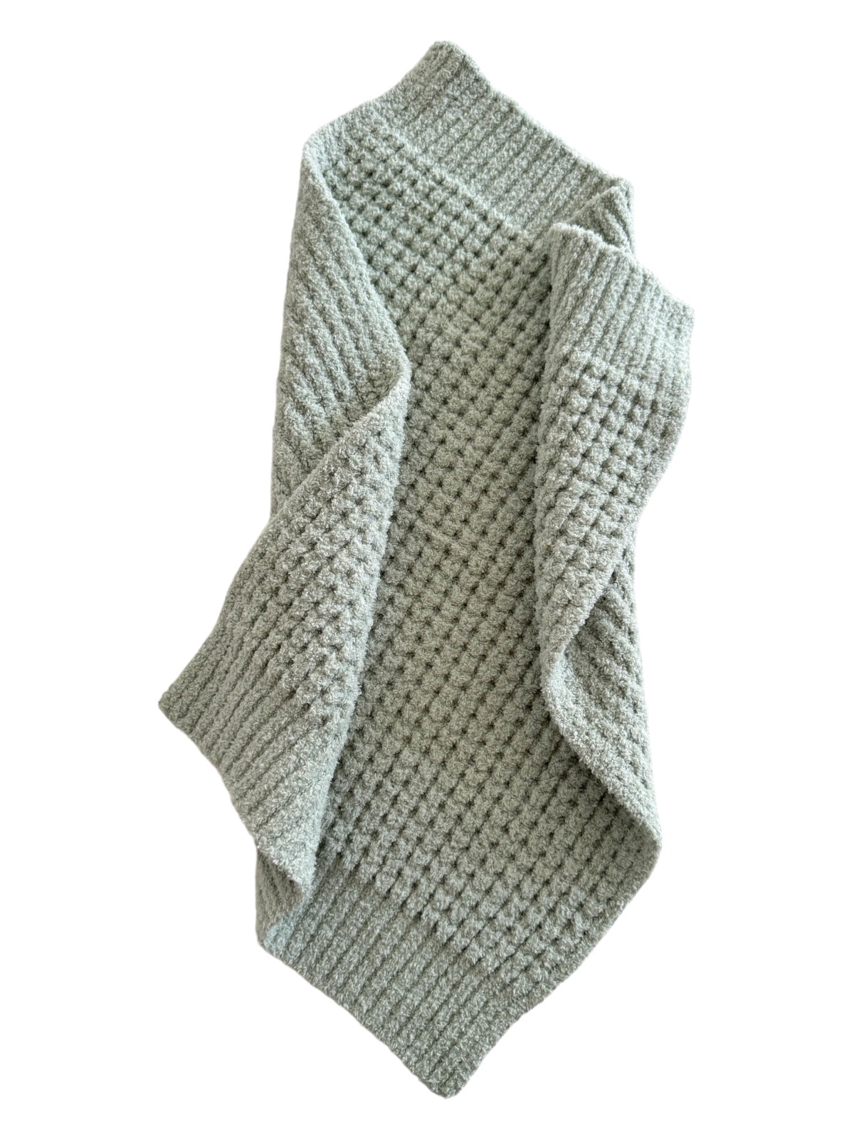 Textured light green blanket draped elegantly, showcasing its soft, cozy fabric.