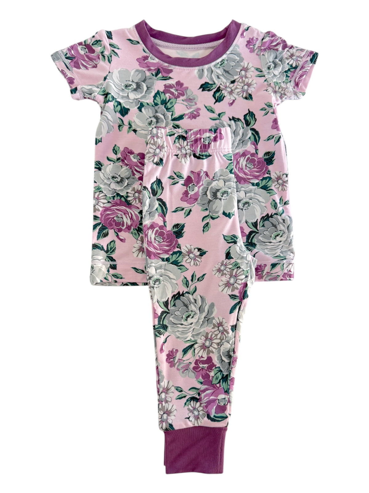 Floral children's pajama set featuring short sleeves and pants with a pink background and purple accents.
