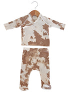 Tan and cream baby pajama set with a patterned top and matching pants, hanging on a wooden hanger.