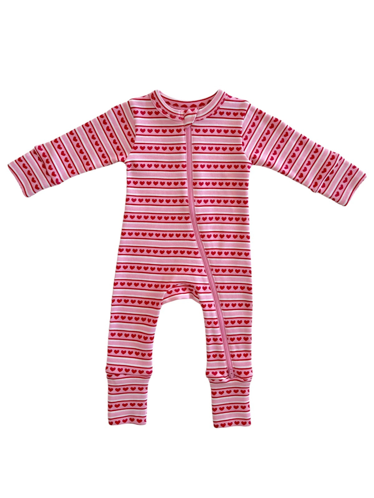 Pink baby onesie with red heart patterns and a front zip closure. Perfect for comfort and style.