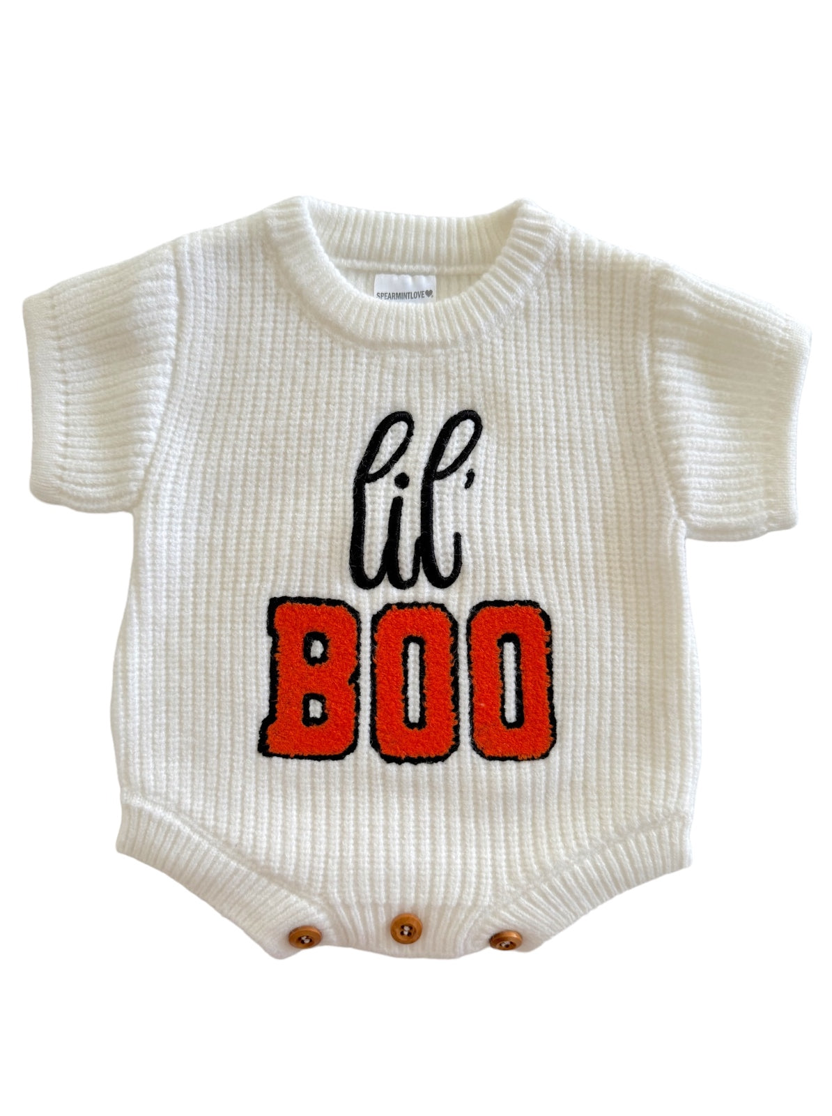 White baby onesie with "lil' BOO" in black and orange lettering, featuring short sleeves and snap buttons at the bottom.