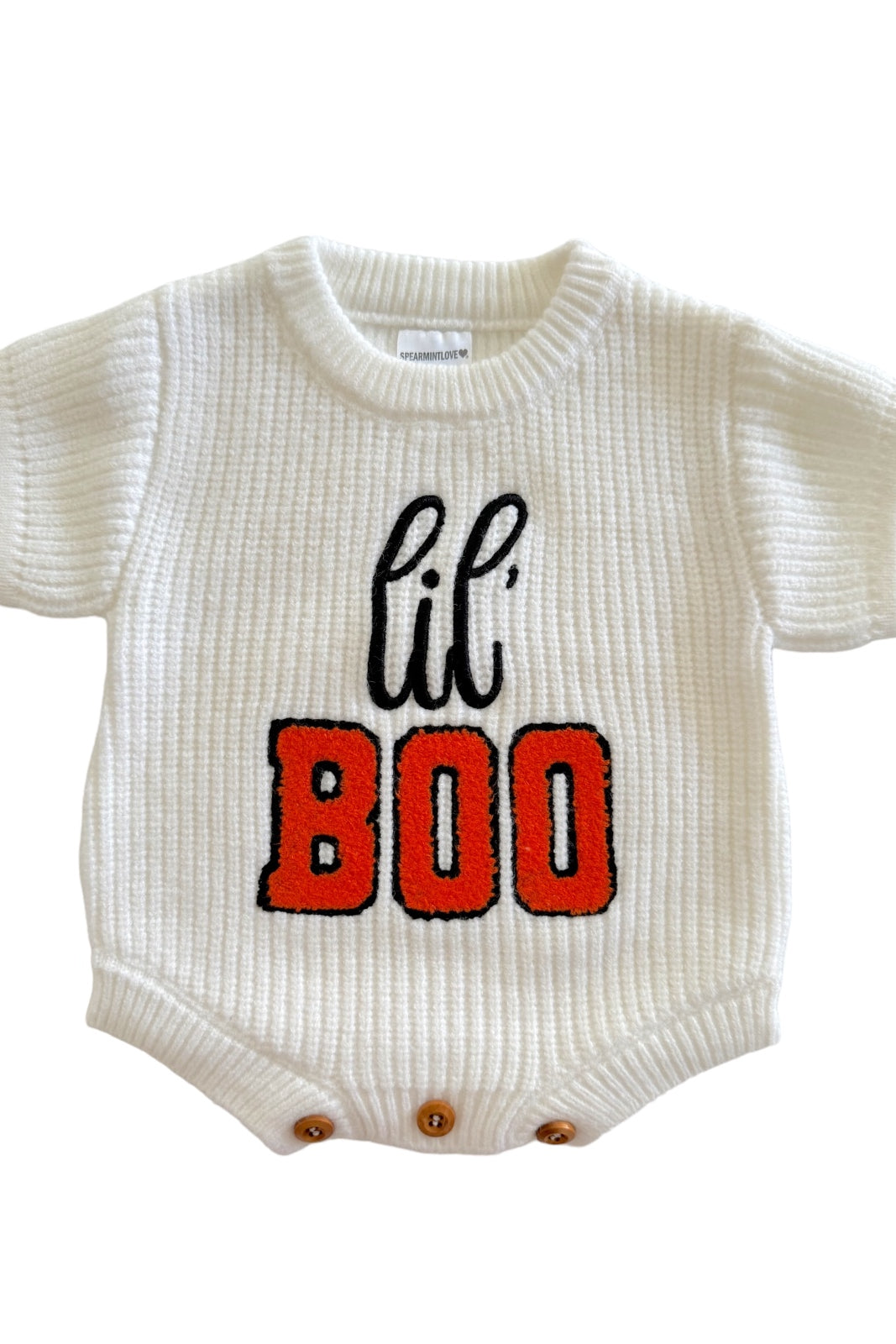 White baby onesie with "lil' BOO" in black and orange lettering, featuring short sleeves and snap buttons at the bottom.