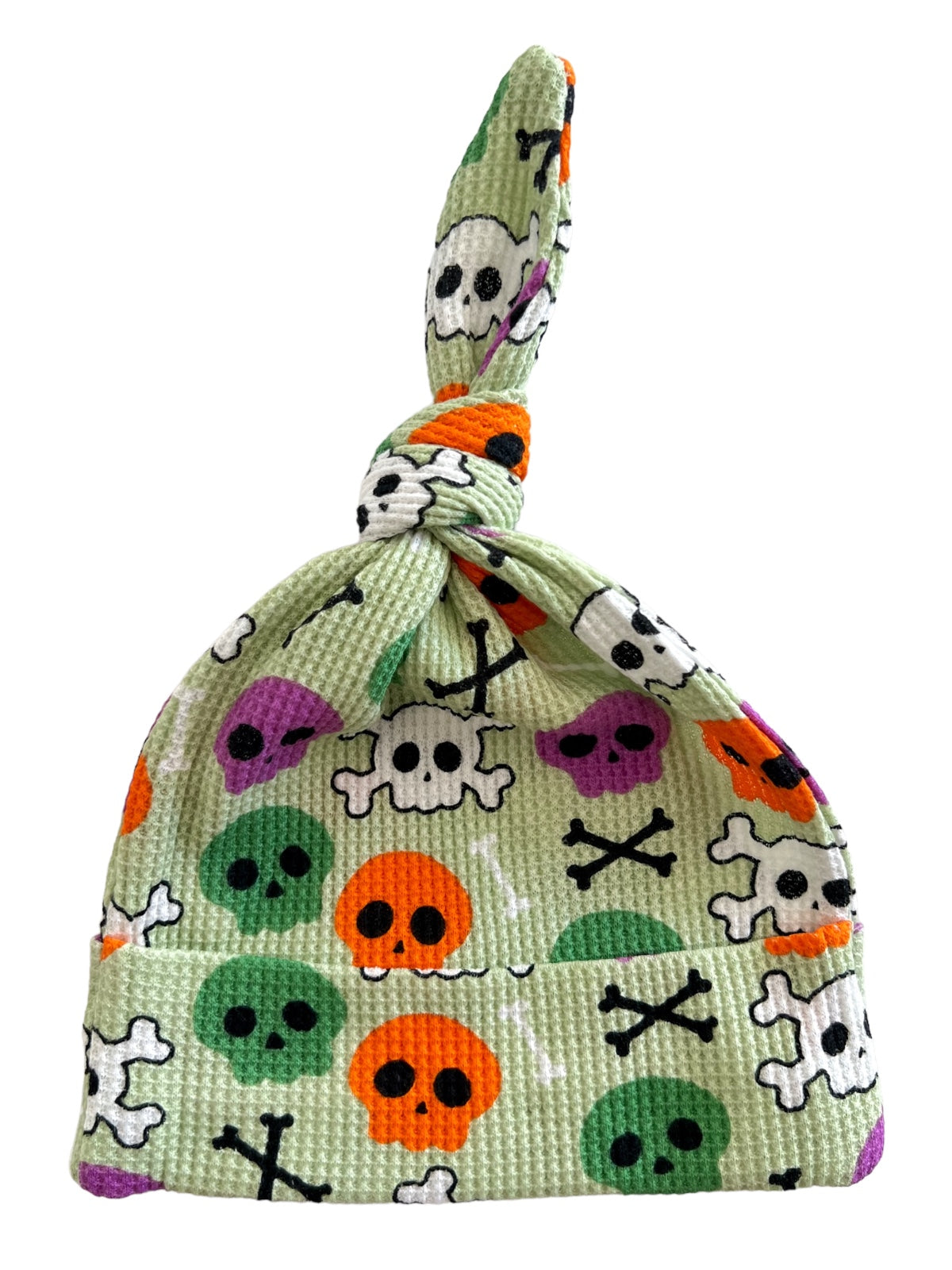 Green skull-patterned hat with knots, featuring colorful skulls and crossbones design.