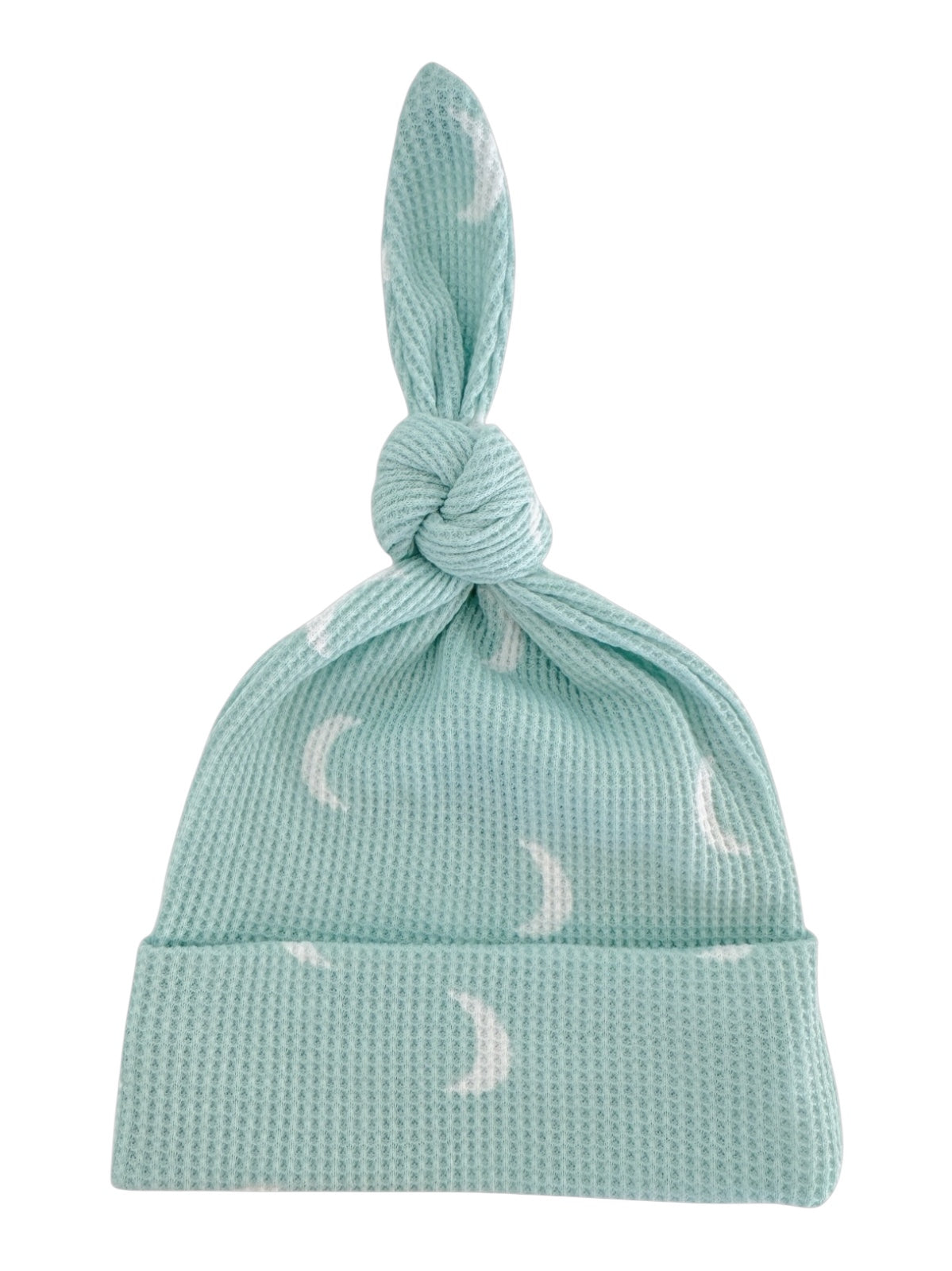 Light blue baby hat with a knot on top and white crescent moon patterns.