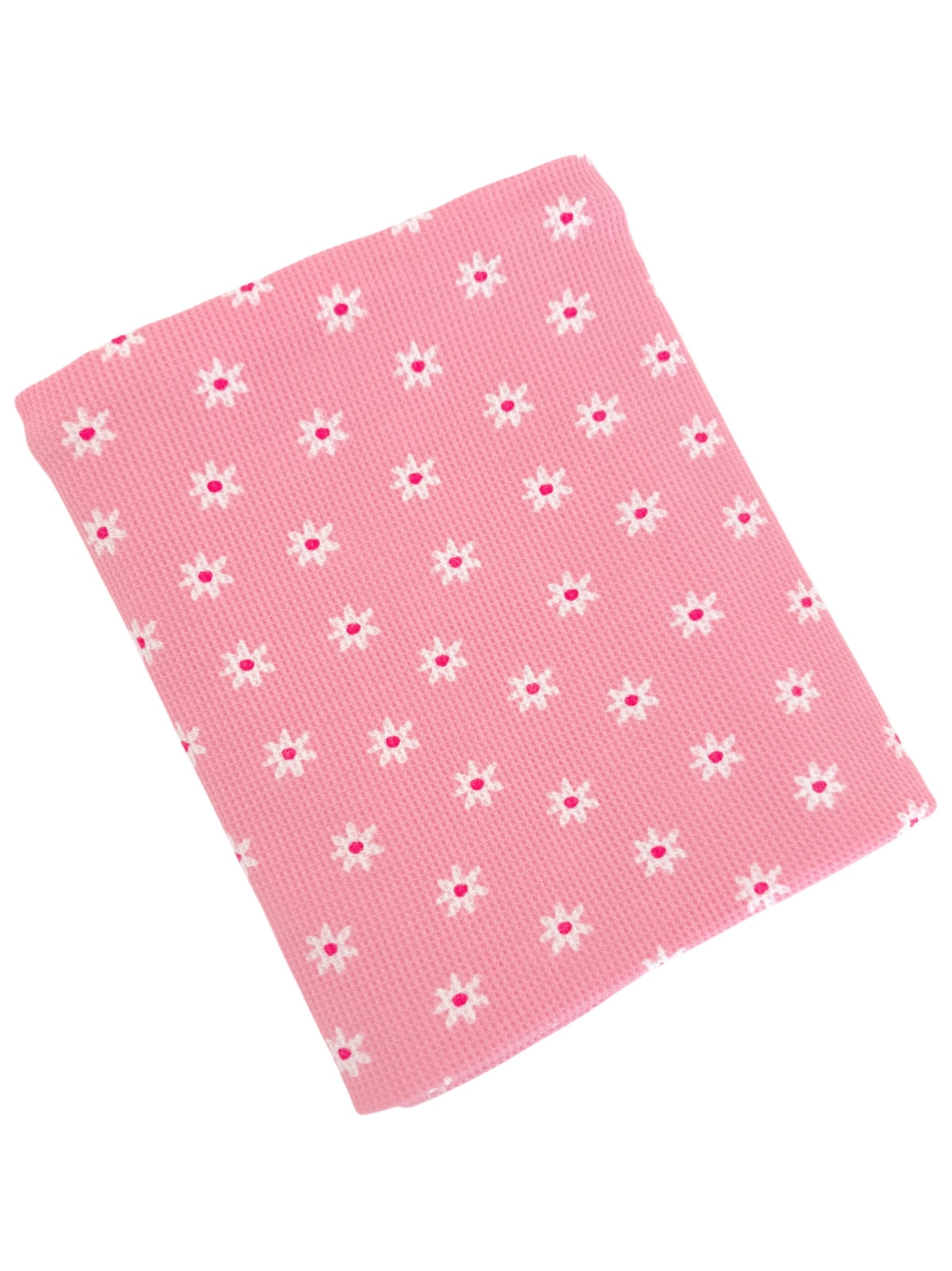 Pink fabric with a textured pattern featuring small white flowers and pink centers sprinkled throughout.