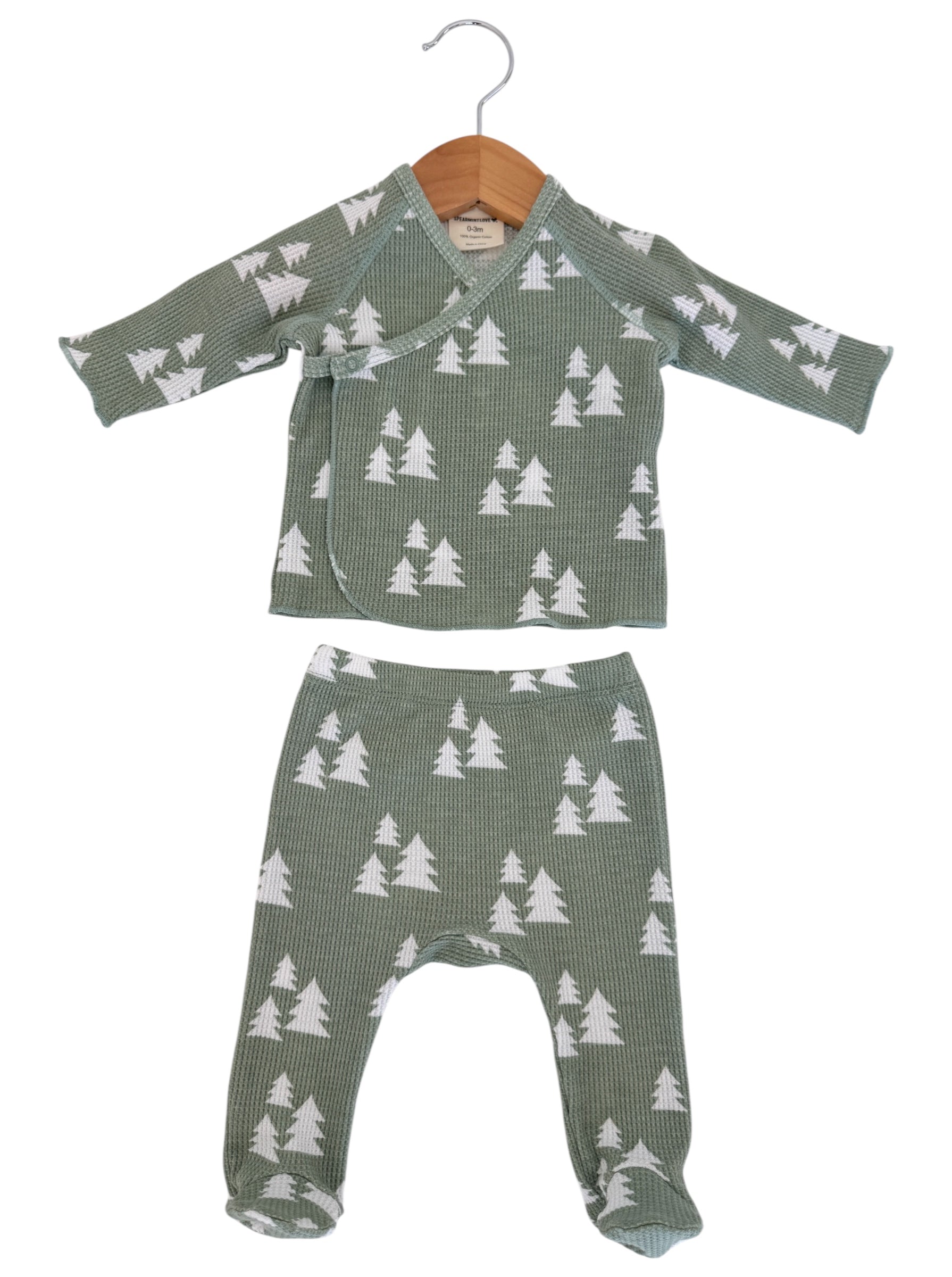 Green baby outfit with long-sleeve top and pants, featuring white tree patterns on a textured fabric.