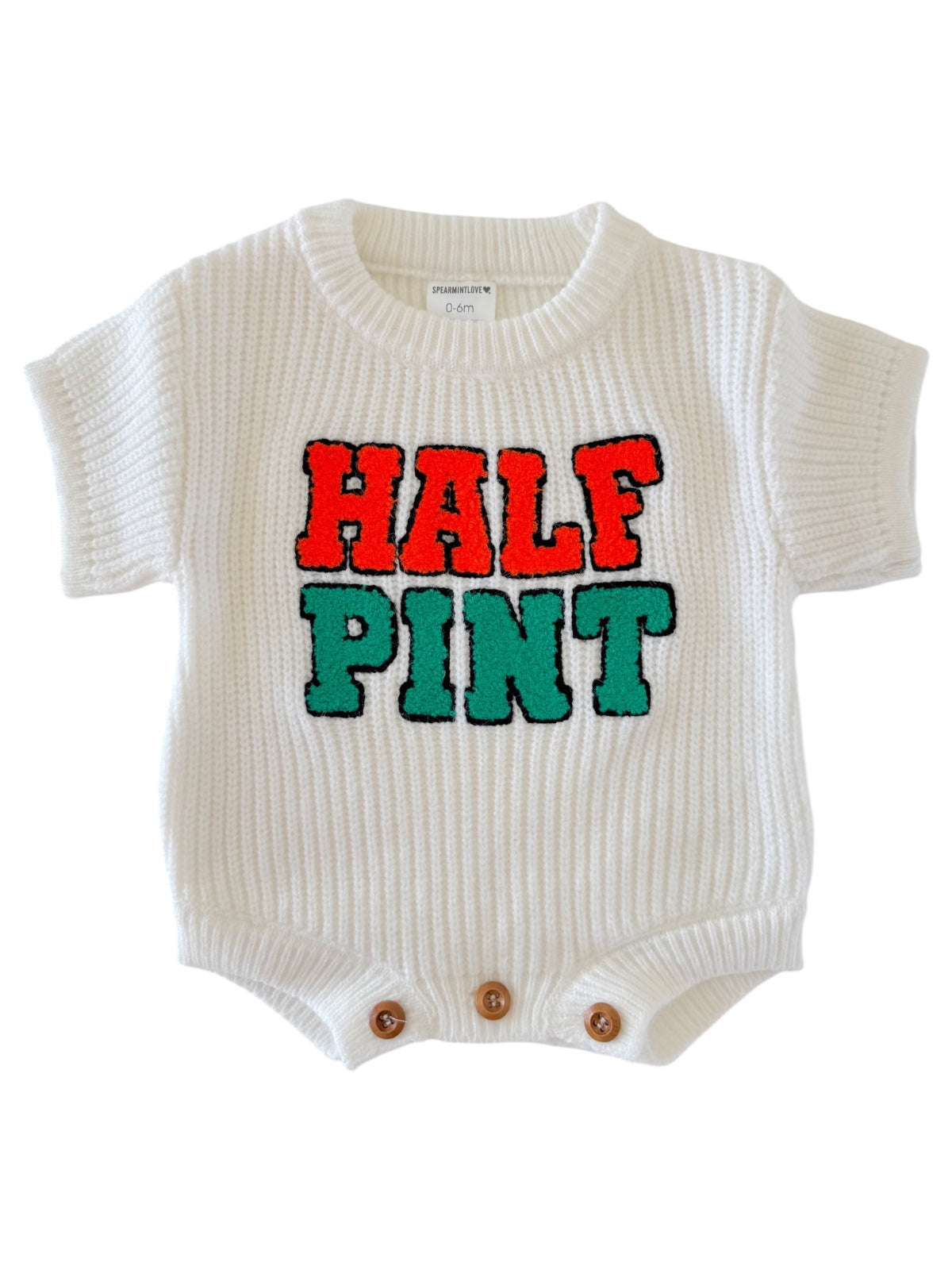 White knitted baby onesie with "HALF PINT" text in red and green. Features short sleeves and button closure.
