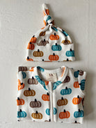 Infant clothing set featuring a pumpkin print onesie and matching knotted hat in autumn colors.
