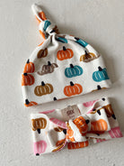 Infant hats and headbands featuring colorful pumpkin patterns on a white background. Size 0-6 months.