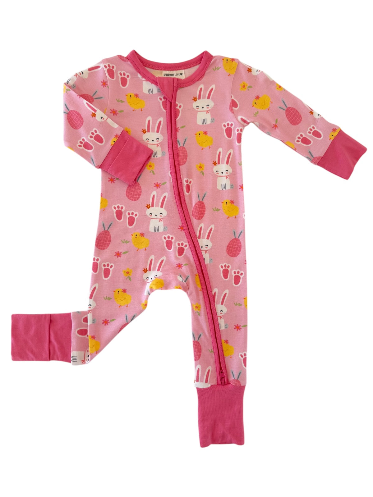 Pink children's onesie featuring bunnies, chicks, and pineapples, with long sleeves and a zip front.