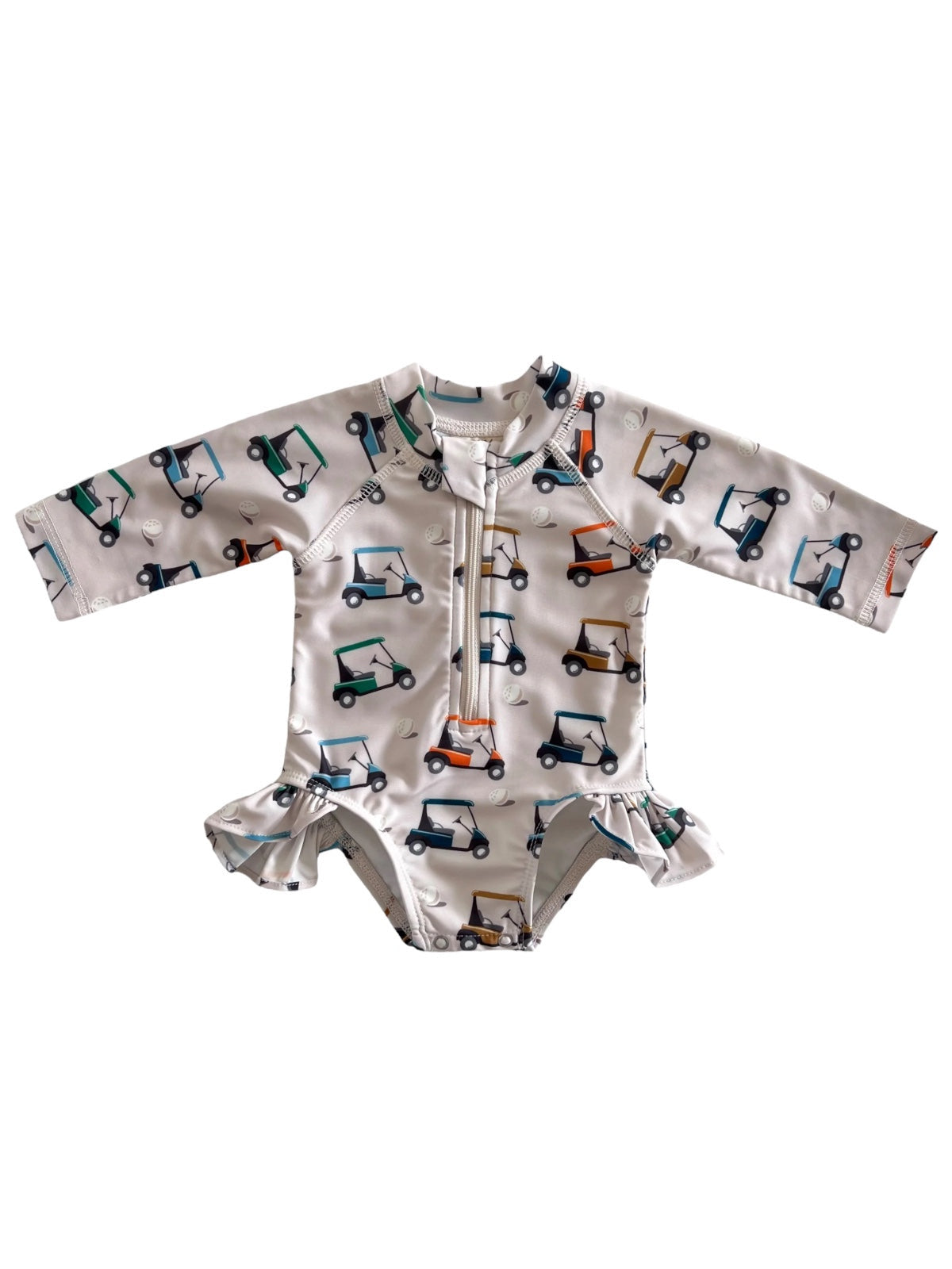 Children's golf cart swimsuit, long-sleeved with ruffle details and colorful cart prints on a light background.