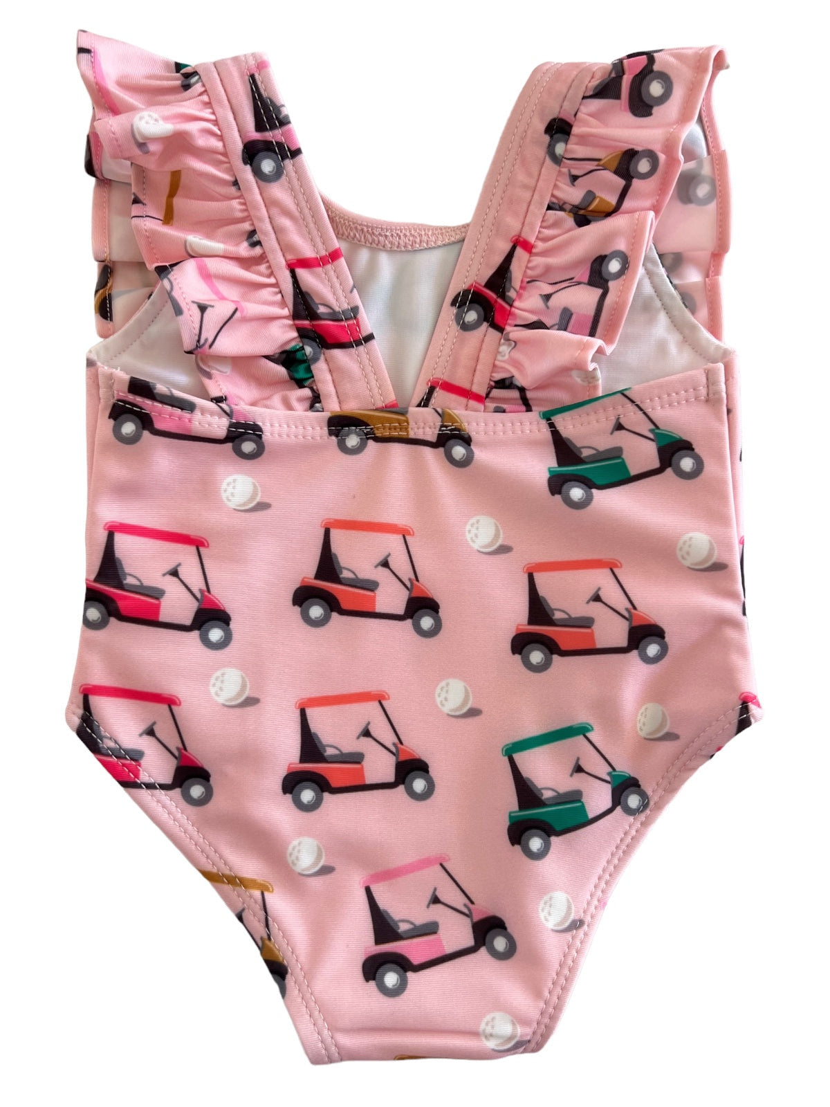 Pink bathing suit with ruffled straps, featuring playful golf cart and ball patterns. Perfect for summer fun.