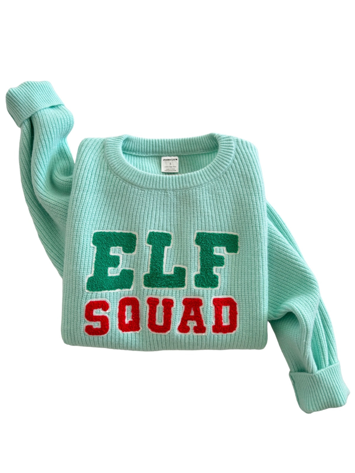 Mint green sweater with "ELF SQUAD" text in red and green letters, folded on a white background.