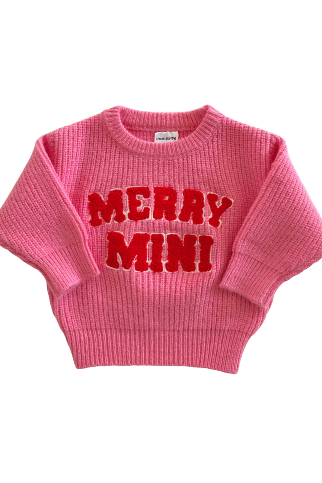 Pink sweater with "MERRY MINI" text, featuring a ribbed texture and wide sleeves. Perfect for festive occasions.