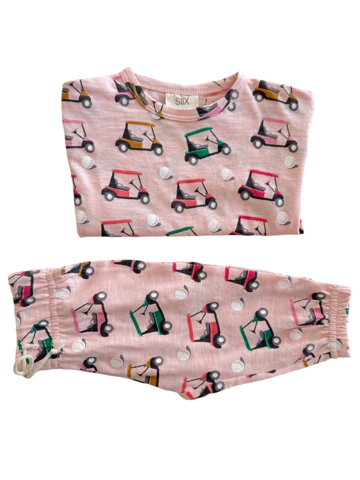 Light pink pajamas featuring colorful golf carts and golf balls print. Soft fabric designed for comfort.