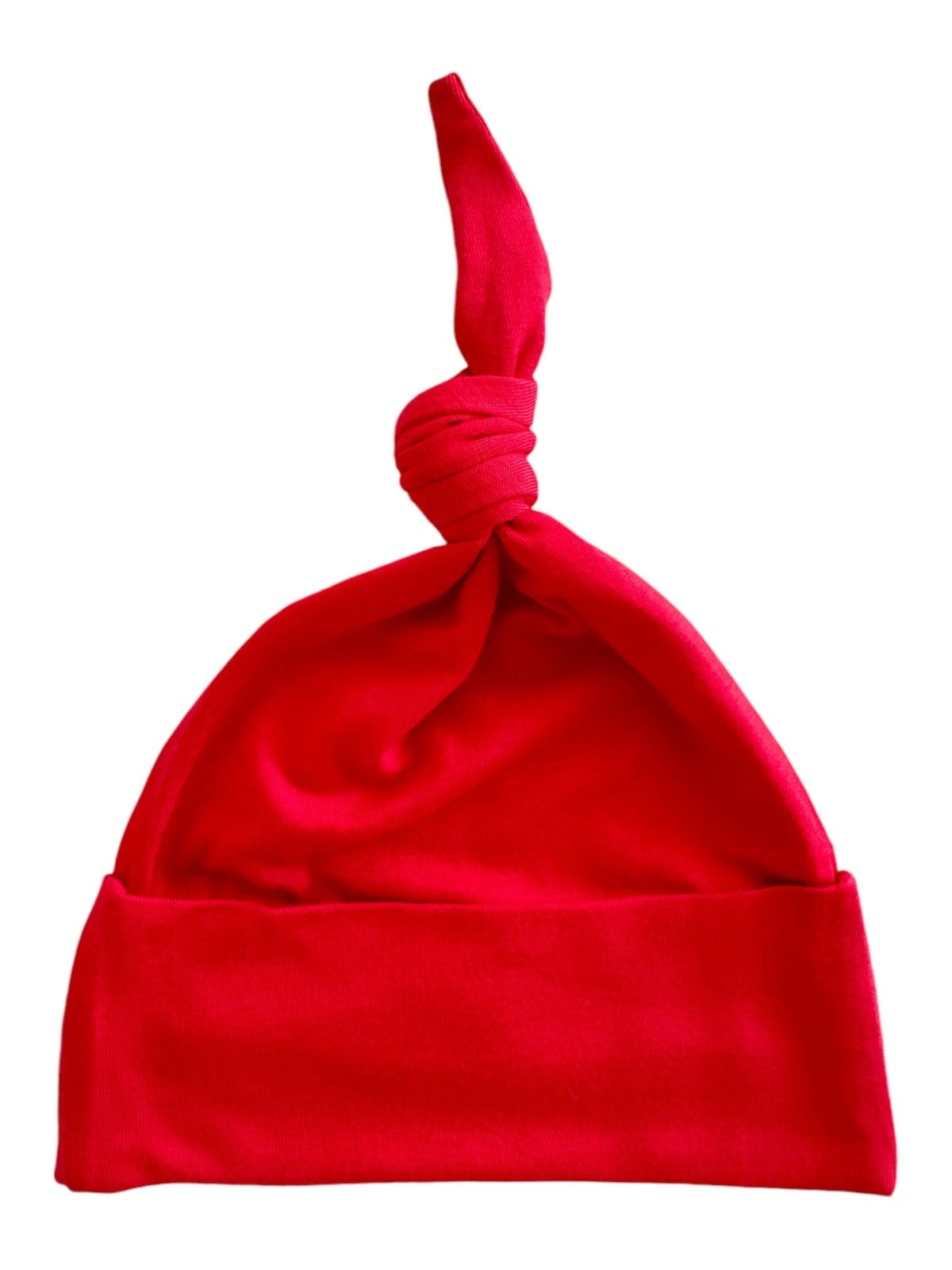 Red cotton beanie hat with a knotted top and a folded brim, ideal for stylish warmth.