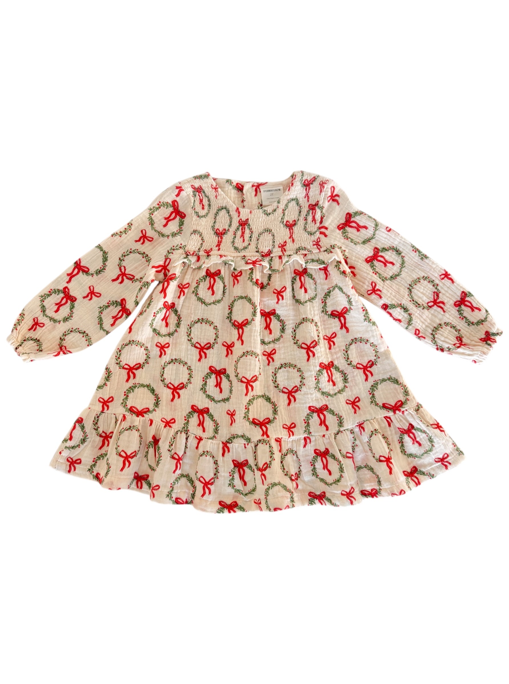 Cream dress with festive wreath and bow pattern, featuring long sleeves and a flared skirt. Perfect for holiday occasions.