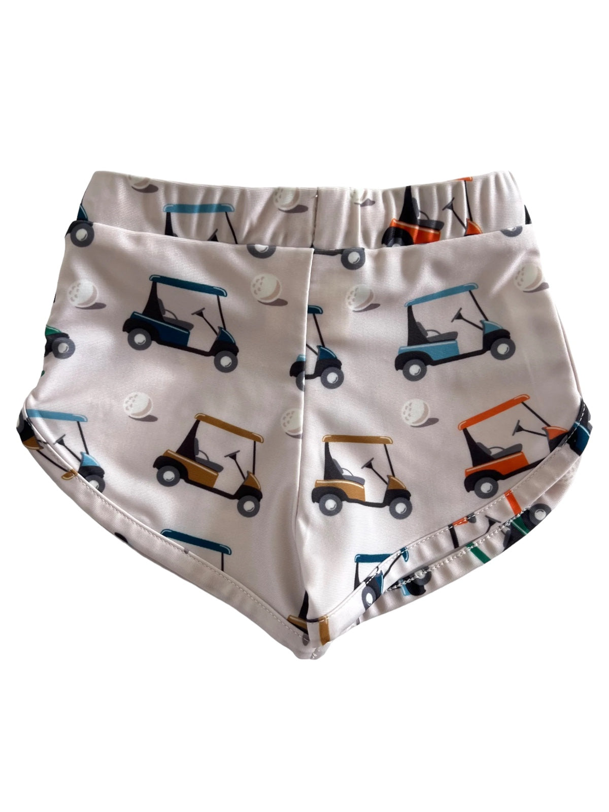 Shorts with a playful golf cart and golf ball pattern in various colors on a light background.