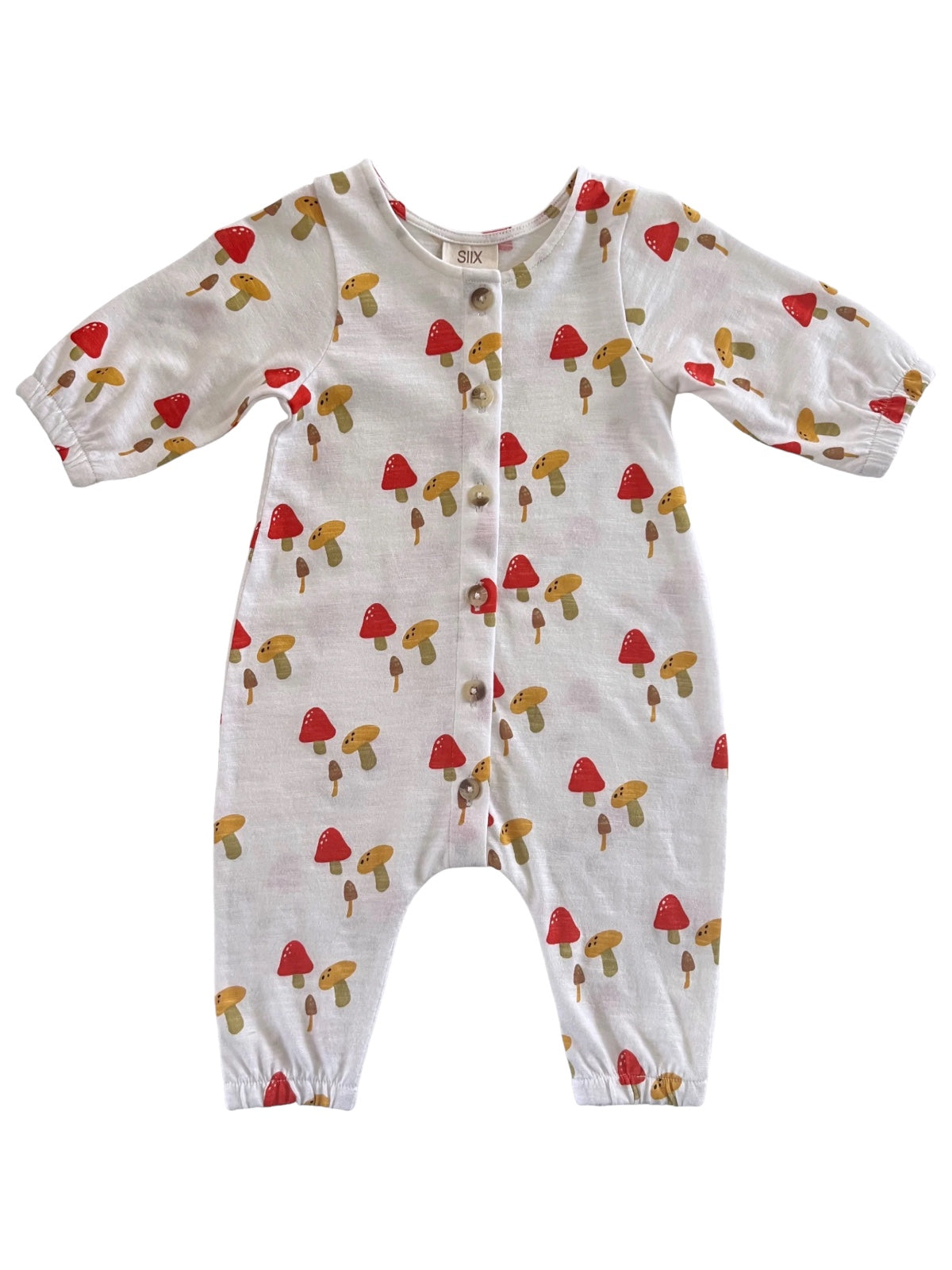 Child's romper featuring a playful mushroom print in red and tan on a white background.
