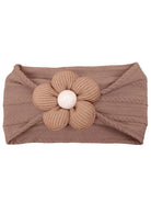 Brown headband with a textured design and a large, ribbed flower embellishment at the front.